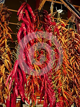 Vertical shot of colorful hot chili peppers hanging at a food market