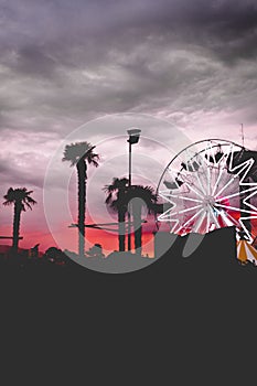 Vertical shot of colorful skies and a Ferris wheel with free space for text