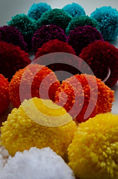 Vertical shot of colorful wool pom poms for fabric decoration