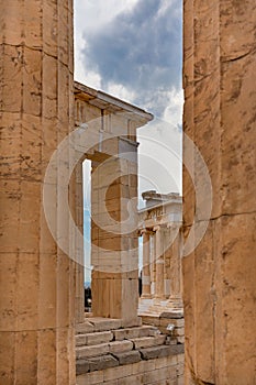 Vertical shot of columns of the Temple of Athena Nike in Athens, Greece against a gray cloudy sky