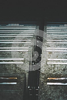 Vertical shot of concrete stairway into the dark deep. Moody and industrial atmosphere