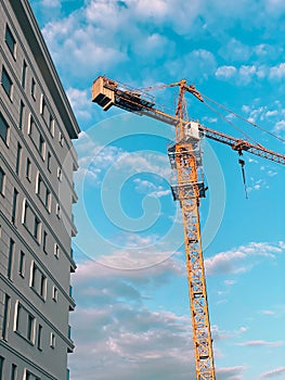 Vertical shot of a construction crane near a building