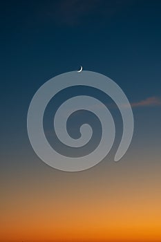 Vertical shot of a crescent moon in a peaceful sunset sky over Texas