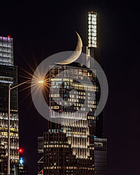 Vertical shot of Crescent moon setting behind Comcast Technology Center in Philadelphia photo