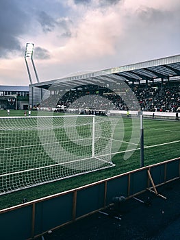 Vertical shot of crowded soccer stadium under cloudy sky