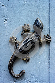 Vertical shot of decorative metallic lizard on the wall