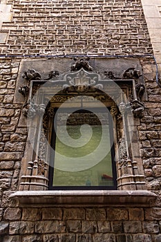 Vertical shot of the detail over a window on the stone wall of Picasso Museum in Barcelona, Spain