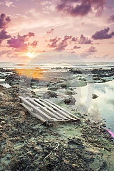 Vertical shot of a dirty coast of the sea under the beautiful sunset sky