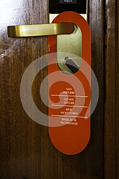 Vertical shot of the Do Not Disturb sign hanging on the hotel room door handle