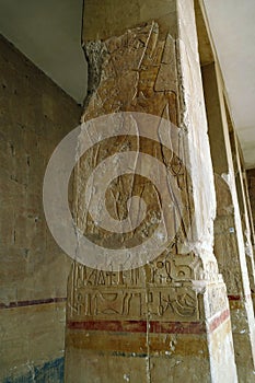 Vertical shot of Egyptian god and hieroglyphics carved on the column