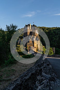 Vertical shot of Eltz Castle surrounded by trees on a sunny day