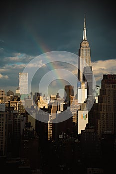 Vertical shot of the Empire State Building in New York City, rainbow over the city