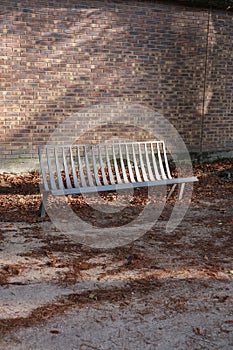 Vertical shot of an empty bench in the Garden of Plants in Paris, France photo
