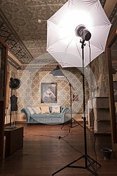 Vertical shot of an empty vintage style photo studio interior with lightning pieces of equipment