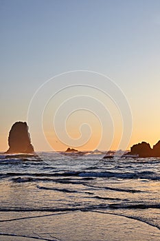 Vertical shot of the famous Haystack Rock on the rocky shoreline of the Pacific Ocean