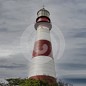 Vertical shot of a Faro De La Memoria Mar lighthouse with cloudy sky in the background in Argentina photo