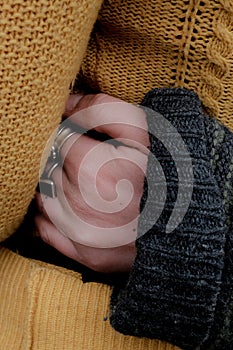 Vertical shot of a female with a sweater and her hand with beautiful silver rings