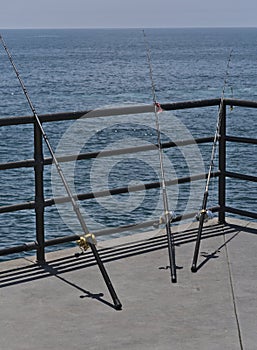 Vertical shot of fishing rods in Huntington beach, La Joya and Santa Monica California photo