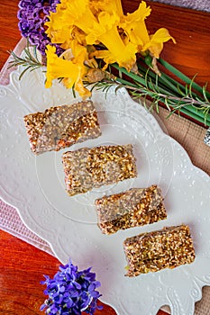 Vertical shot of Flex Seed Bread Pie pieces on a napkin with yellow and violet flowers on the side