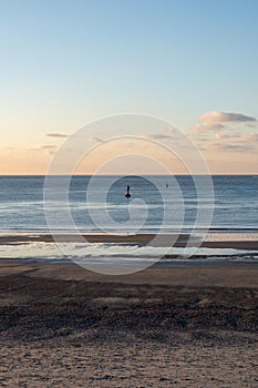 Vertical shot of a floating navigational buoy floating in a calm sea in Norderney, Germany