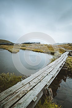 Vertical shot fo a wooden dock over a lake in Finse, Norway