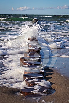 Vertical shot of a foamed water on the breakwater