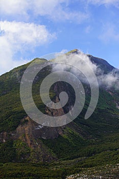 Vertical shot of forested Mountain Papandayan in the clouds, West Java