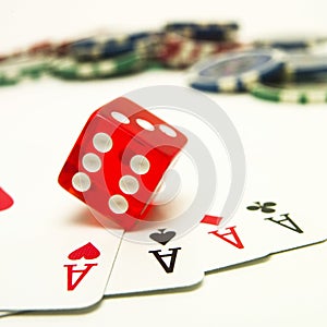 Vertical shot of four aces, a dice, and gambling chips
