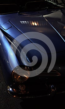 Vertical shot of the front details of a classic blue car