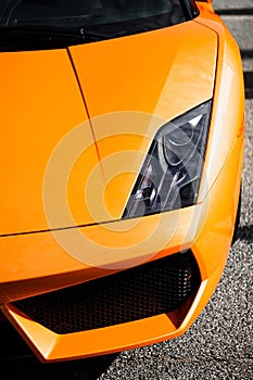 Vertical shot of the front of an orange luxurious Lamborghini Gallardo car