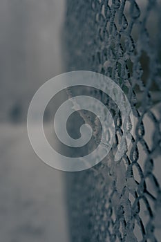 Vertical shot of a frozen and snowy wire fence