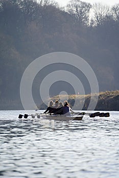 Vertical shot of girls sailing a small boat in the lake