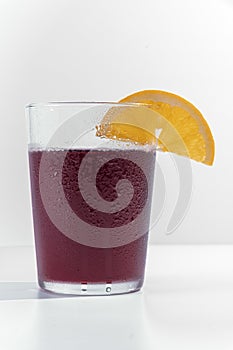 Vertical shot of a glass of iced drink with a slice of lemon isolated on a white backgroun