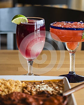 Vertical shot of glasses of iced drinks and a dish on a wooden table