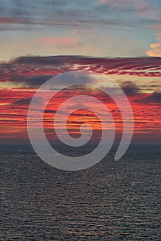 Vertical shot of a gorgeous fiery sunset sky above the calm sea on the Ramsgate coast