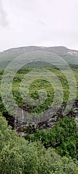 Vertical shot of the green Akerneset mountain under cloudy sky in More og Romsdal, Norway