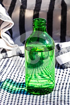Vertical shot of a green bottle of water on a table