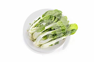 Vertical shot of green leafy vegetables on a glass bowl isolated on a white background