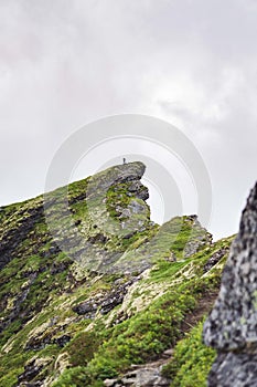 Vertical shot of a green rock near the Reinebringen village of the Lofoten Islands