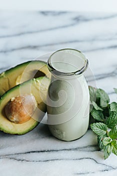 Vertical shot of green smoothie and avocadoes on the white background