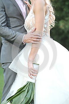 Vertical shot of the groom and the bride posing for a romantic wedding photoshoot