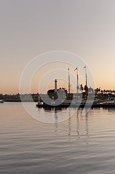 Vertical shot of a harbor with boats and ships at the sunset