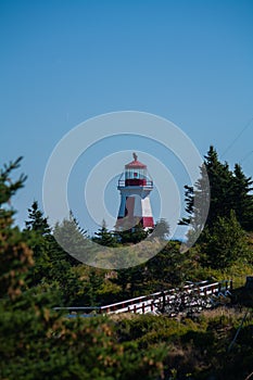 Vertical shot of the Head Harbour Lightstation on a blue sky background in Campobello, New Brunswick