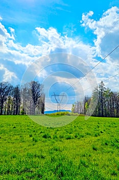 Vertical shot of high-voltage wires against the blue sky