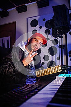 Vertical shot of a Hispanic boy sitting near the synthesiser