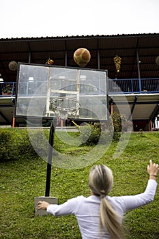 Vertical shot of a Hispanic woman with blonde hair playing basketball