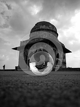 Vertical shot of a historic building in Mandav, India, reflected in a crystal ball