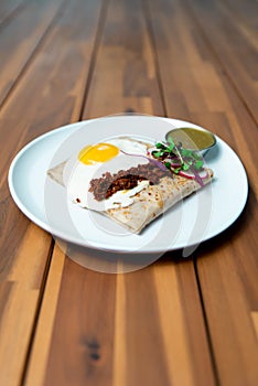 Vertical shot of a Huevos ranchero dish with a fried egg and a Mexican sauce