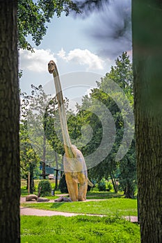 Vertical shot of a huge dinosaur statue in a park