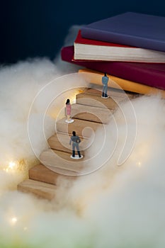 Vertical shot of human figures climbing up wooden stairs - heaven concept